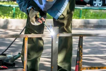 Professional welder repairing metal gate structure