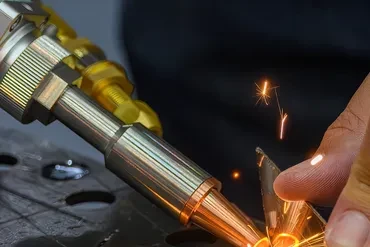 Professional welder working on large steel pipe with sparks flying